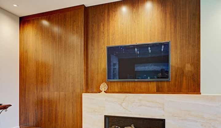 The Dunfield Wall-unit design features large panels of natural walnut, with hidden doors that open using BLUM TIP-ON mechanisms.