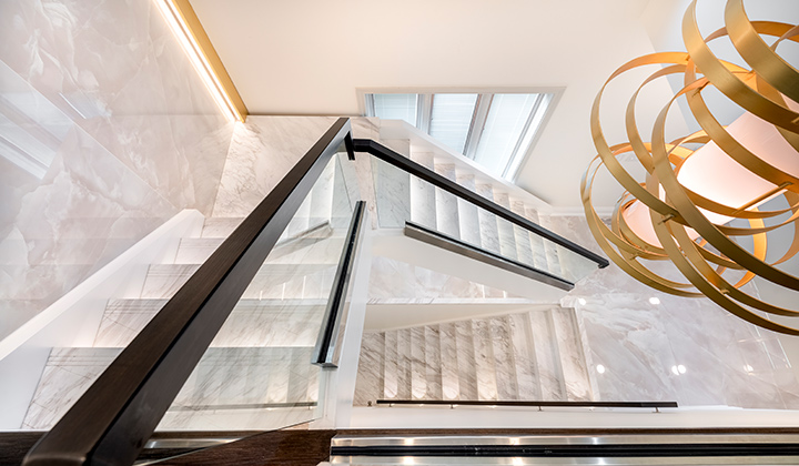 A redesigned contemporary staircase with marble stair treads and brass inlays. Here the marble treads create a beautiful art piece by having the pronounced veins follow from one tread to the other. Part of our commercial project for Dr. Solomon Facial Plastic Clinic. Toronto, Yorkville.