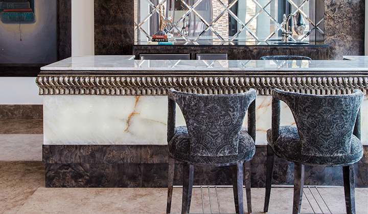 A custom bar design featuring intricate, handcrafted finishes that merge marble, wood, and metal to create a space of exclusive sophistication